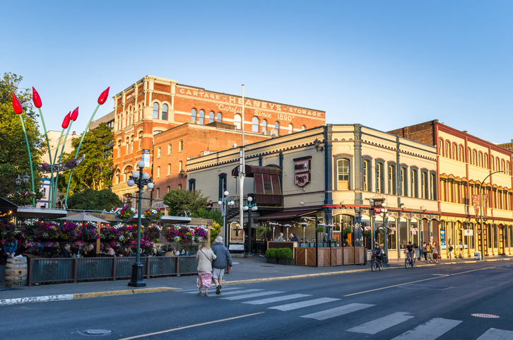 Victoria, BC - June 28, 2017: People Sitting on the Patios of Some Pubs and Restaurants at the Entrance of Bastion Square at Sunset. In the heart of downtown Victoria, Bastion Square is the original site of old Fort Victoria. The square looks out on the Inner Harbour and boasts the finest restaurants, pubs, and cafes in Victoria.